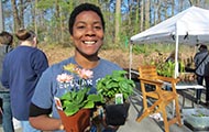 a smiling woman holding plants