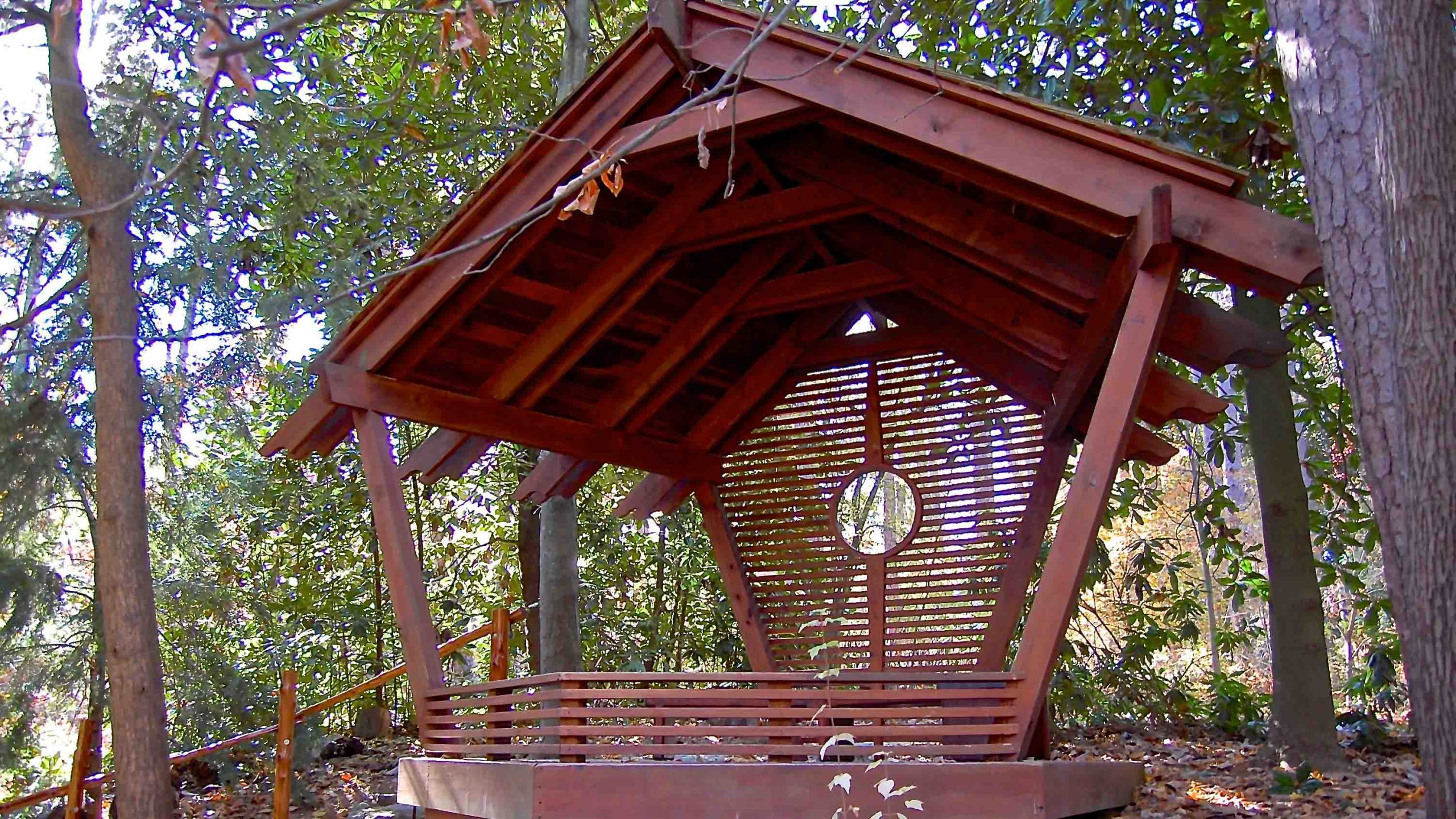 A couple sits together in a wooden pavilion; an example of the formal portraiture covered by Duke Gardens' photography policies.